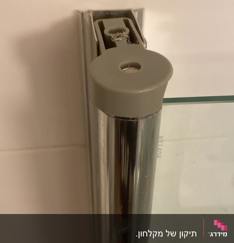 חלק ממסגרת זכוכית של מקלחון עם מחבר מתכת